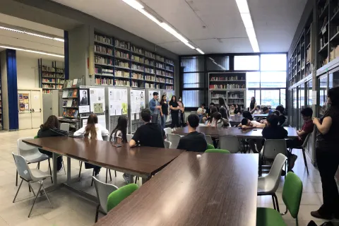 Sala biblioteca con alunni intorno ai tavoli